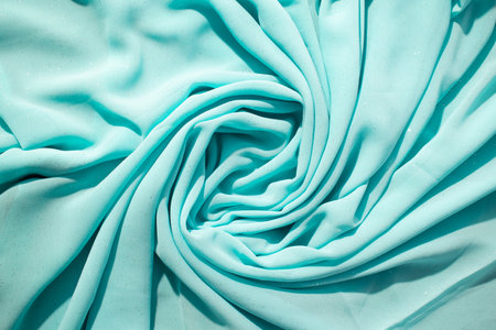 Spiral Twisted Turquoise wavy crumpled fabric with little sparkling dust, texture and  background.の写真素材