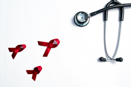 Red ribbon and stethoscope, HIV awareness concept, world AIDS day, world cancer day isolated white background.の写真素材