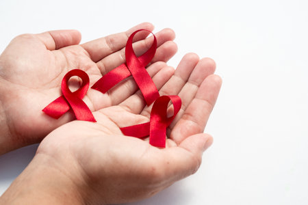 Female hand hold red ribbon, HIV awareness concept, world AIDS day, world cancer day isolated white...