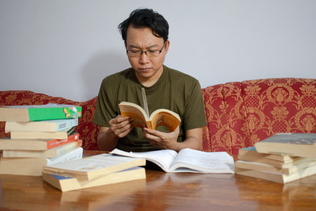 Asian young student study, reading and writing sit on sofa at living room. Isolated white backgroundの写真素材