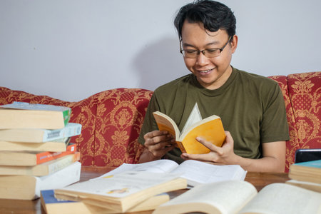 Asian young student study, reading and writing sit on sofa at living room. Isolated white backgroundの写真素材