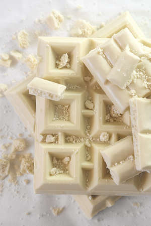 White chopped in pieces chocolate on light background in monochrome. Top view.の写真素材