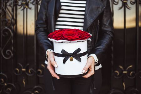 Bouquet of red roses in a box in the hands of the girl.の写真素材
