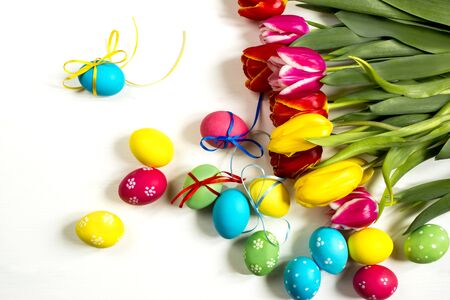 colorful bouquet of tulips Easter eggs decorated with ribbons in the nest on a white background