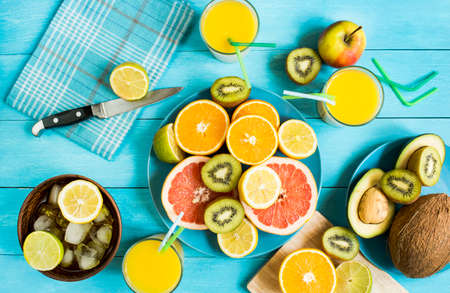 Citrus fruit juice ice knife on a blue wooden table top view