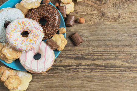 donut breakfast biscuits  and crockery on a wooden table top viewの写真素材