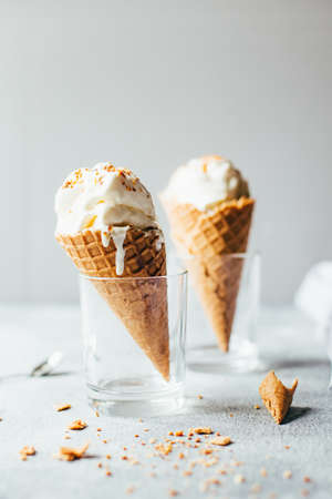 close-up of two white ice creams in waffle cups on gray backgroundの写真素材