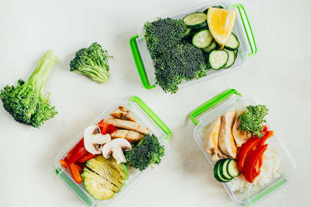 top view of vegetables, rice, meat in plastic bowls on light white backgroundの写真素材