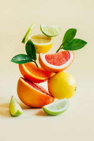 pyramid of citrus fruits grapefruit, orange, lemon, lime on yellow backgroundの写真素材