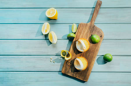 top view of lemon and lime citrus fruits, lemon brownie on rustic board on light blue wooden backgroundの写真素材