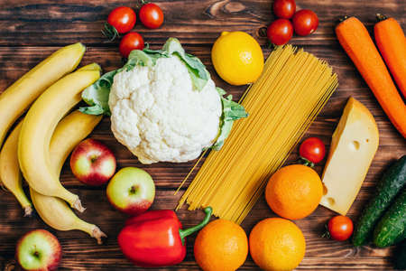 top view set of food vegetables fruits dairy products on wooden backgroundの写真素材
