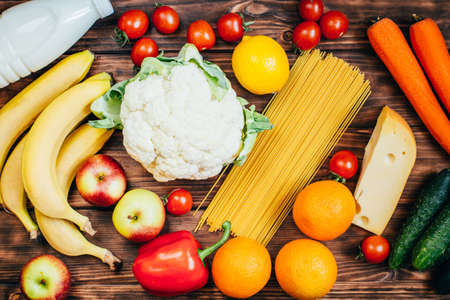 top view set of food vegetables fruits dairy products on wooden backgroundの写真素材