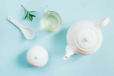 top view of a set of tea utensils teapot sugar bowl cup with tea on a blue backgroundの写真素材