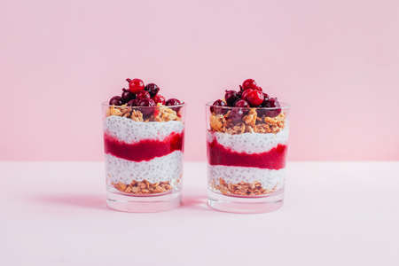 close-up of chia pudding with granola yogurt currants in a transparent glass on a pink backgroundの写真素材