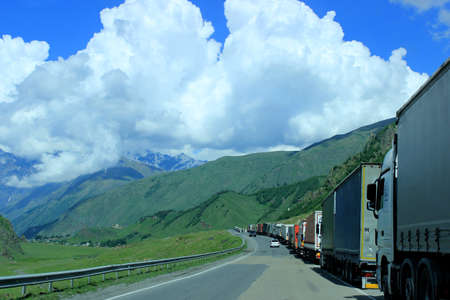 Queue of trucks waiting in line for border customs control, Georgian Military Road, Georgia. A...