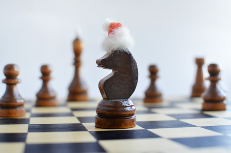 New Year on a chessboard, chess pieces in Santa's cap on a light backgroundの写真素材