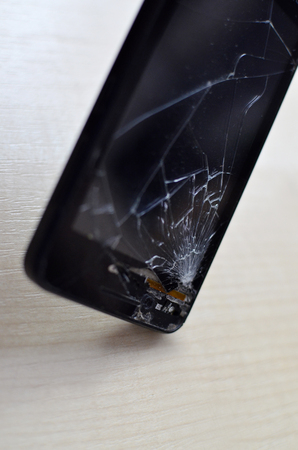 Broken screen cell phone on gray background.Smartphone Insurance and Mobile phone warranty concept. angle, close-upの写真素材