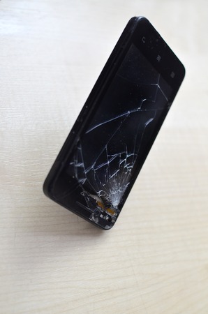 Broken screen cell phone on gray background.Smartphone Insurance and Mobile phone warranty concept. close-upの写真素材