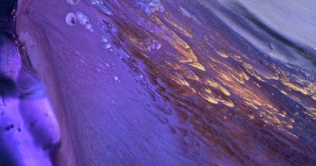 Purple gold paint. Flowing lilac color glitter paint texture. Fluid art painting abstract. Shine colorful vertical liquid flow. Luxury glamor golden background. Diagonal glow stripes patternの写真素材