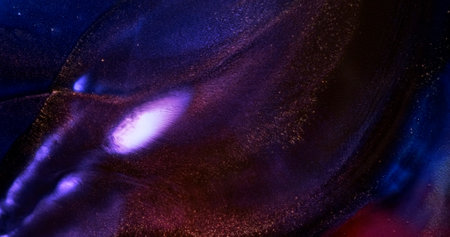 Abstract purple blue dark ink spreads in waves, close-up. Rich black violet. Dark lilac liquid texture. Vertical video. Sparkling gold glitter spreads. fluid art. Shining abstract backgroundの写真素材