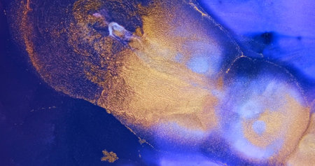 Gold particles sparkle, flow in purple paint abstract background. Shiny ink spread, splash in purple liquid. Shining, shimmering colorful pattern texture. Gold blue moving splash fluid art backdropの写真素材