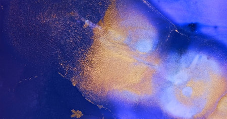 Gold particles sparkle, flow in purple paint abstract background. Shiny ink spread, splash in purple liquid. Shining, shimmering colorful pattern texture. Gold blue moving splash fluid art backdropの写真素材