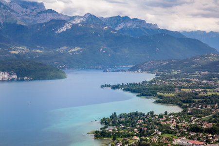 View of the Annecy lake surrounded of mountains with cityscape in cloudy weather. Rhone Alps, France.3の写真素材