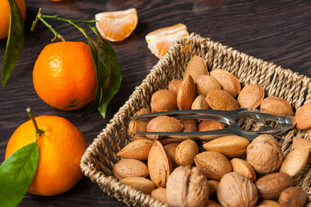 mandarins and nuts on a wooden tableの写真素材