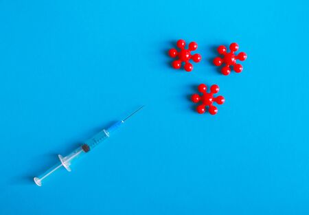 Syringe and red molecule of virus in blue backgroundの写真素材