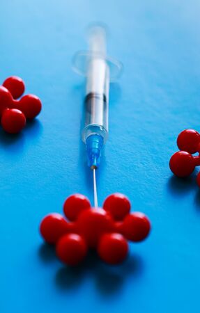 Syringe and red molecule of virus in blue backgroundの写真素材