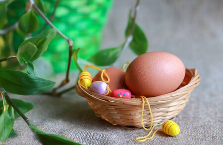 Easter eggs in the basket on sackcloth backgroundの写真素材