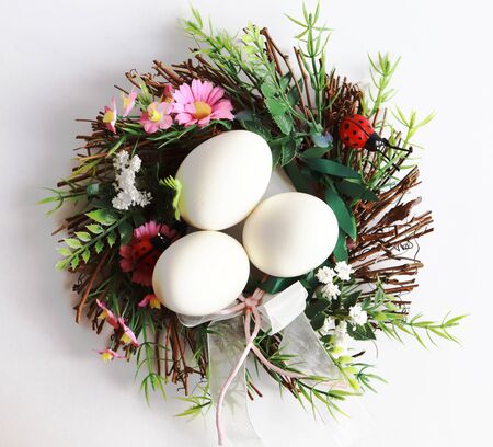 Easter eggs and decorational wreath on white backgroundの写真素材