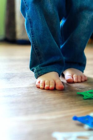 Legs of a little boy who is standing on the floor