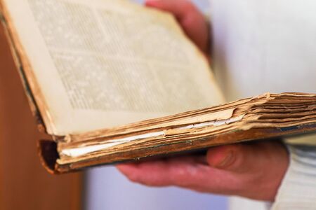 An old man holding an old book