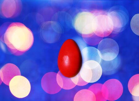 Red easter egg on colorful abstractlights background, festive bokehの写真素材