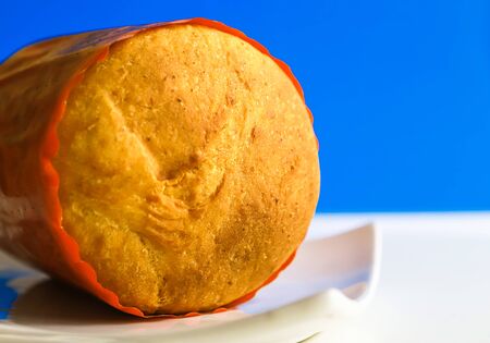 Homemade wheat bread on white plate on blue background. Bake pies at homeの写真素材
