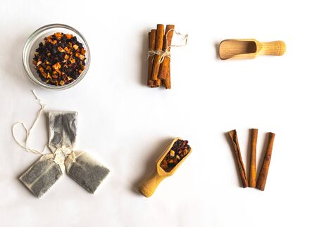 Herbal floral fruit in glass socket, wooden spoon, cinnamon stick and tea bags. Flat lay