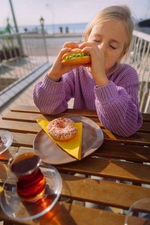 Little girl choosing to eat healthy sandwich instead of donut. High quality photoの写真素材