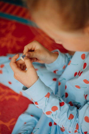 Little girl playing with colourful blocks, girls hands holding coloured stone, cute little girl in blue pyjama playing at home. High quality photoの写真素材