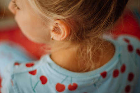 Selective focus on little girls hair while she is looking to the left, view from back, close up, tender childs photo. High quality photoの写真素材