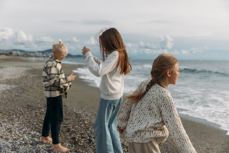 Selective focus on a group of kids having fun at beach in cold weather. concept of children freedom High quality photoの写真素材