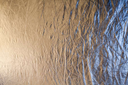 Photography reflector material in silver color, reflecting sunlight and a bit of sky.の写真素材