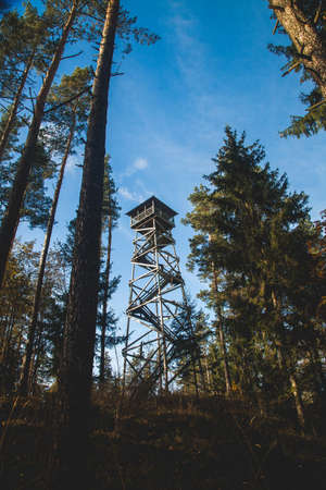 Wooden tower in a forest on top of hill on a sunny autumn day.の写真素材