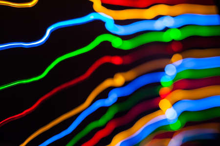 Colorful bright red, yellow, blue and green mixed Christmas lights flowing in various directions...