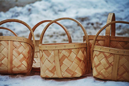Multiple wooden baskets placed on snow covered surface during a winter festival outdoor market.の写真素材