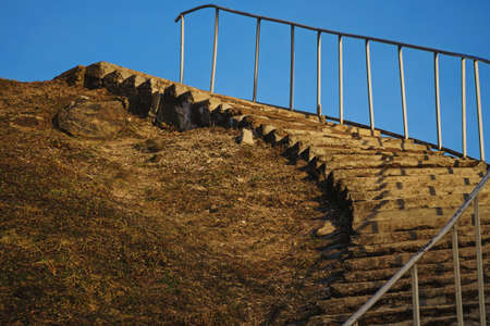 Long concrete stairs leading to top of a hill on a spring sunset clear blue sky on backgroundの写真素材