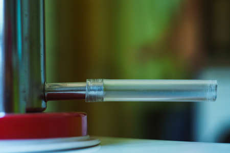 Colorful close up picture of home mechanical juicer with red base standing on white glossy table clean prepared for pressing juiceの写真素材