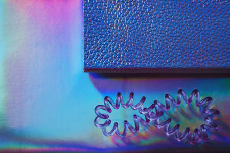 Abstract picture of set of holographic feminine objects - two various notebooks and cable hair band
