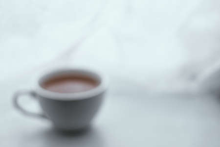 Blurred background image of simple white cup filled with tea on the left on white backgroundの写真素材