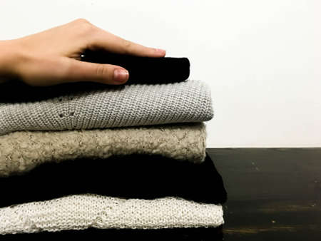 A hand touching a pile of colorful wool sweaters warm fluffy soft and comfortable to wear.の写真素材